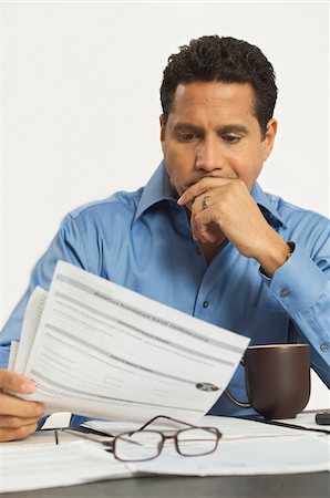 simsearch:694-03329423,k - Man Reading a Tax Form Foto de stock - Sin royalties Premium, Código: 694-03329419