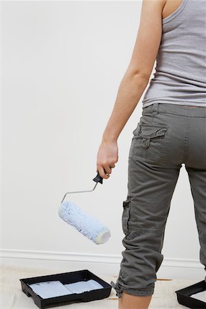 Woman holding paint roller by blank wall, mid section Stock Photo - Premium Royalty-Free, Code: 694-03329543