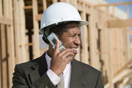 Surveyor using mobile phone on construction site Stock Photo - Premium Royalty-Free, Code: 694-03321767
