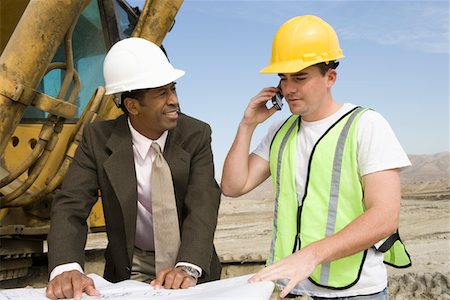 Surveyor and construction worker studying blueprint Stock Photo - Premium Royalty-Free, Code: 694-03321831