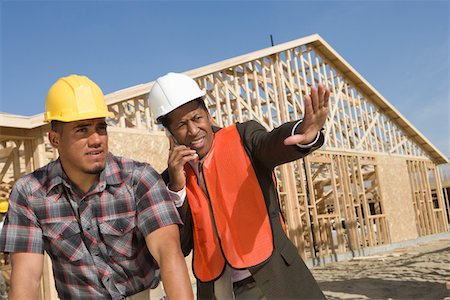 Architect and construction worker leaning to table with blueprints Stock Photo - Premium Royalty-Free, Code: 694-03321972