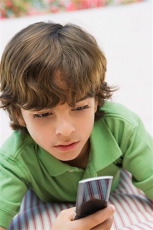 Young Boy Using Cell Phone Stock Photo - Premium Royalty-Free, Code: 694-03330484