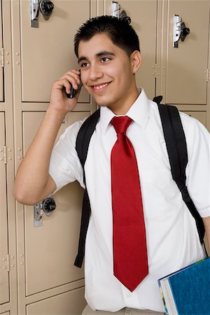 High School Boy Using Cell Phone by School Lockers Stock Photo - Premium Royalty-Free, Code: 694-03331084