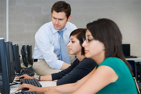 female teenagers students in a class - Teacher Helping Computer Students Stock Photo - Premium Royalty-Free, Code: 694-03331139