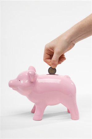 Hand Putting Money in Piggy Bank Stock Photo - Premium Royalty-Free, Code: 694-03331484