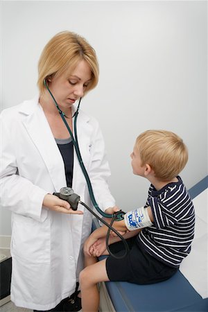 Female doctor taking blood pressure of boy Stock Photo - Premium Royalty-Free, Code: 694-03331693