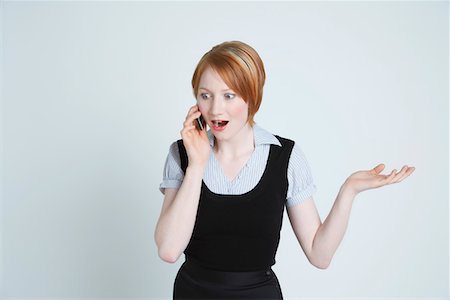 people shocked on phones - Studio shot of businesswoman talking on mobile phone Stock Photo - Premium Royalty-Free, Code: 694-03331809