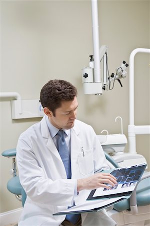 doctor looking at xray - Dentist leafing through medical record Stock Photo - Premium Royalty-Free, Code: 694-03332131