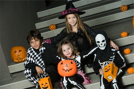 Portrait of boys and girls (7-9) wearing Halloween costumes on steps Stock Photo - Premium Royalty-Free, Code: 694-03332179