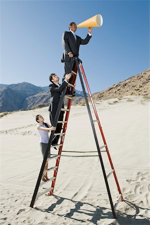 Gens d'affaires sur l'escabeau à l'aide de porte-voix dans le désert Photographie de stock - Premium Libres de Droits, Code: 694-03332426