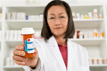 simsearch:694-03332775,k - Female pharmactist holding prescription drugs Stock Photo - Premium Royalty-Free, Code: 694-03332794