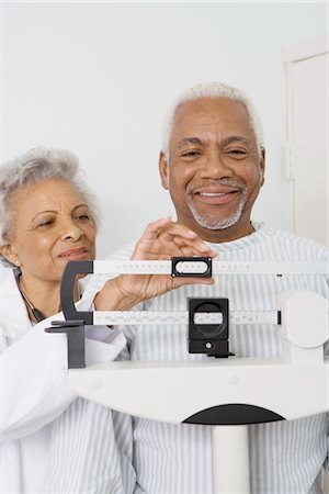 Senior medical practitioner checks weight of patient Stock Photo - Premium Royalty-Free, Code: 694-03332861