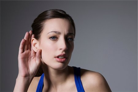 Brunette with hand behind ear Stock Photo - Premium Royalty-Free, Code: 694-03333054