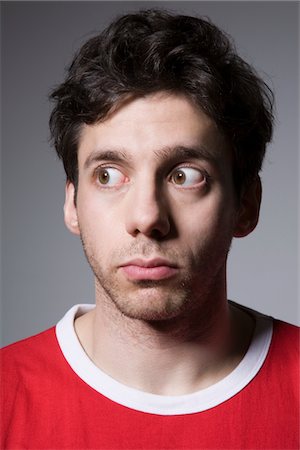 soupçon (suspicion) - Jeune homme au sommet rouge à la recherche sur le côté Photographie de stock - Premium Libres de Droits, Code: 694-03333062