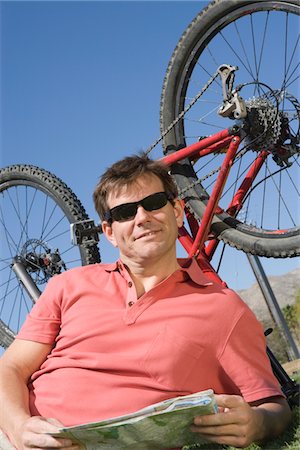 fossetta - Mature man lies with ma, bike upside down Fotografie stock - Premium Royalty-Free, Codice: 694-03474677