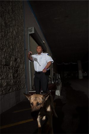 Garde de sécurité dans la poursuite de ruelle et chien de garde Photographie de stock - Premium Libres de Droits, Code: 694-03474732