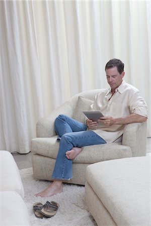 simsearch:694-03557939,k - Man sits reading a digital book Foto de stock - Sin royalties Premium, Código: 694-03557934