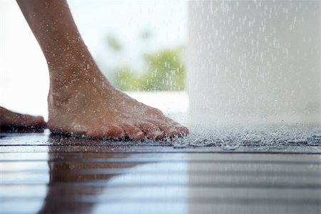 Woman standing under outdoor shower, close up of feet, low section, Stock Photo - Premium Royalty-Free, Code: 694-03694093