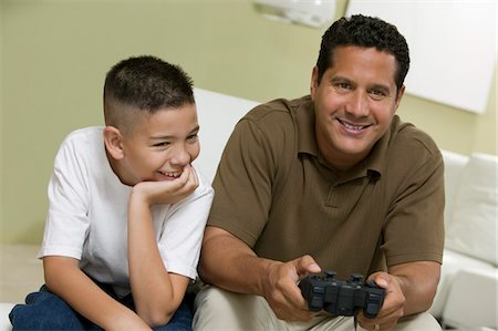 simsearch:694-03318038,k - Son with father Playing Video Game on sofa in living room Stock Photo - Premium Royalty-Free, Code: 694-03692151