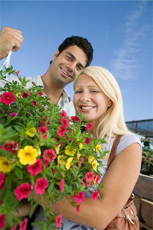 simsearch:694-03692195,k - Couple standing in plant nursery Holding Hanging Plant, portrait, low angle view Stock Photo - Premium Royalty-Free, Code: 694-03692202