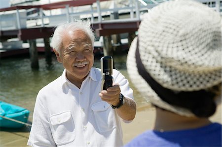 Senior homme femme photographie à l'aide du téléphone-appareil photo, à l'extérieur Photographie de stock - Premium Libres de Droits, Code: 694-03692315