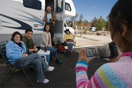 Girl videotaping family outside of RV Stock Photo - Premium Royalty-Free, Code: 694-03692517