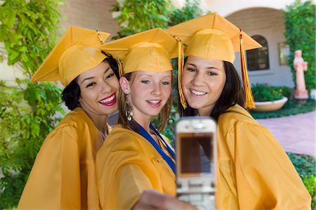 simsearch:693-06014222,k - Graduates taking picture with cell phone outside, front view Stock Photo - Premium Royalty-Free, Code: 694-03692640