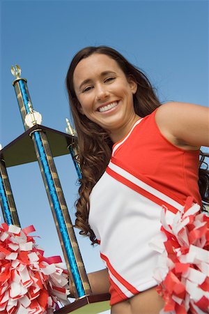 female teen in track and field - Smiling Cheerleader holding trophy, (portrait), (low angle view) Stock Photo - Premium Royalty-Free, Code: 694-03692654