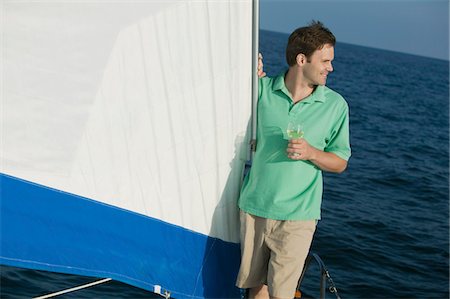 Man standing on sailboat, holding glass of white wine Stock Photo - Premium Royalty-Free, Code: 694-03692809