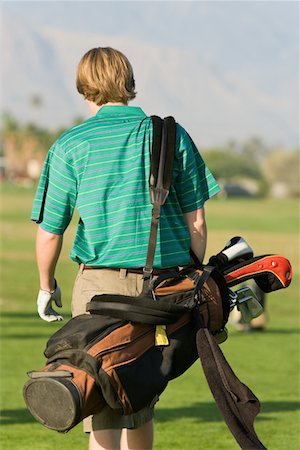 simsearch:694-03783289,k - Golfer walking through green carrying golf bag, back view Stock Photo - Premium Royalty-Free, Code: 694-03692900