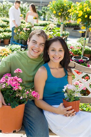 Young couple sitting on bench in garden centre, (portrait) Stock Photo - Premium Royalty-Free, Code: 694-03693029