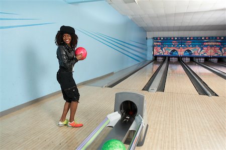 Young woman at bowling alley holding ball, portrait Stock Photo - Premium Royalty-Free, Code: 694-03693401