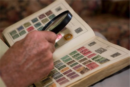 engrandecer - Senior man looks at stamp collection with magnifying glass Foto de stock - Sin royalties Premium, Código: 694-03783265