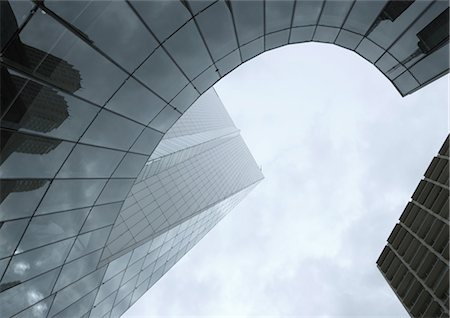 simsearch:632-06118652,k - Skyscraper with reflection of buildings on facade, low angle, abstract view Foto de stock - Sin royalties Premium, Código: 695-05764040