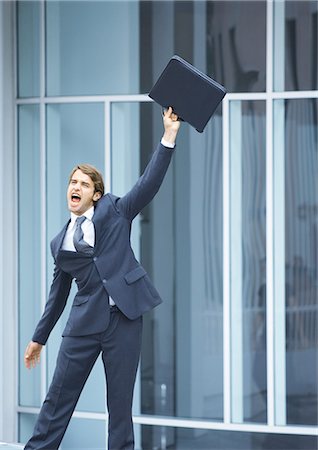 frustrated man with briefcase - Businessman swinging briefcase and shouting Stock Photo - Premium Royalty-Free, Code: 695-05764097