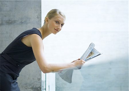 simsearch:632-01157433,k - Woman leaning against glass guard rail, reading newspaper Stock Photo - Premium Royalty-Free, Code: 695-05764115