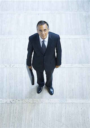simsearch:695-03382908,k - Businessman standing holding briefcase, portrait, high angle view Fotografie stock - Premium Royalty-Free, Codice: 695-05764126