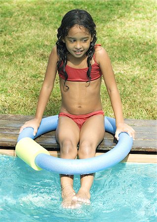 female sitting at edge of pool - Girl sitting on edge of swimming pool Stock Photo - Premium Royalty-Free, Code: 695-05764259