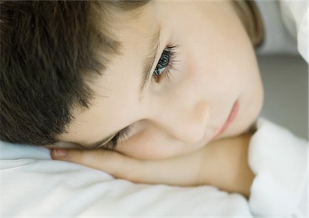 Child lying down, head on pillow, close-up Foto de stock - Sin royalties Premium, Código: 695-05764361