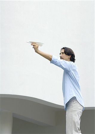 paper airplane - Man standing, aiming paper airplane Stock Photo - Premium Royalty-Free, Code: 695-05764408