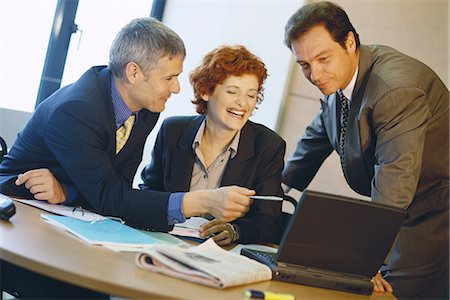 simsearch:6109-06005290,k - Business colleagues using laptop, laughing Stock Photo - Premium Royalty-Free, Code: 695-05764456