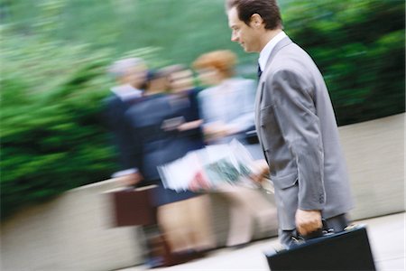 street businessman walking - Businessman carrying bouquet of flowers and briefcase Stock Photo - Premium Royalty-Free, Code: 695-05764516