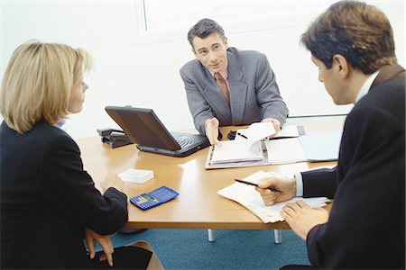 executives on table back - Professional couple sitting in meeting with sales executive Stock Photo - Premium Royalty-Free, Code: 695-05764526