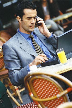 simsearch:695-05765625,k - Homme d'affaires assis dans le café de trottoir, à l'aide d'ordinateur portable et téléphone Photographie de stock - Premium Libres de Droits, Code: 695-05764534