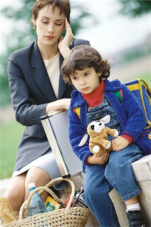 picture of tired woman with shopping bags - Businesswoman sitting with son, holding head Stock Photo - Premium Royalty-Free, Code: 695-05764603