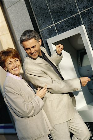 Mature couple standing at ATM machine Fotografie stock - Premium Royalty-Free, Codice: 695-05764671