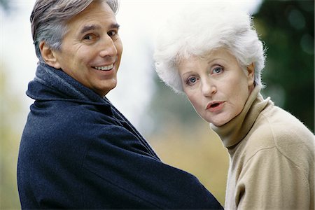 senior couple candid outdoors - Senior couple, looking over shoulder at camera Stock Photo - Premium Royalty-Free, Code: 695-05764702
