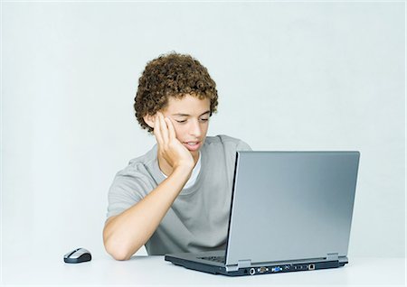 silhouette teen boy not woman not man not girl - Teenage boy using laptop Stock Photo - Premium Royalty-Free, Code: 695-05764791