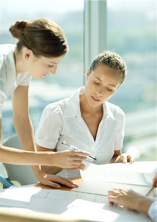 Two women discussing document together Stock Photo - Premium Royalty-Free, Code: 695-05764864
