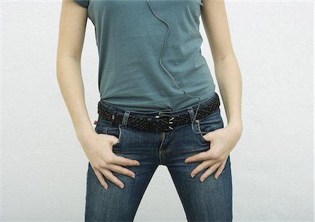 simsearch:695-05764970,k - Young woman standing with thumbs in jean pockets, close-up of mid section Stock Photo - Premium Royalty-Free, Code: 695-05764964